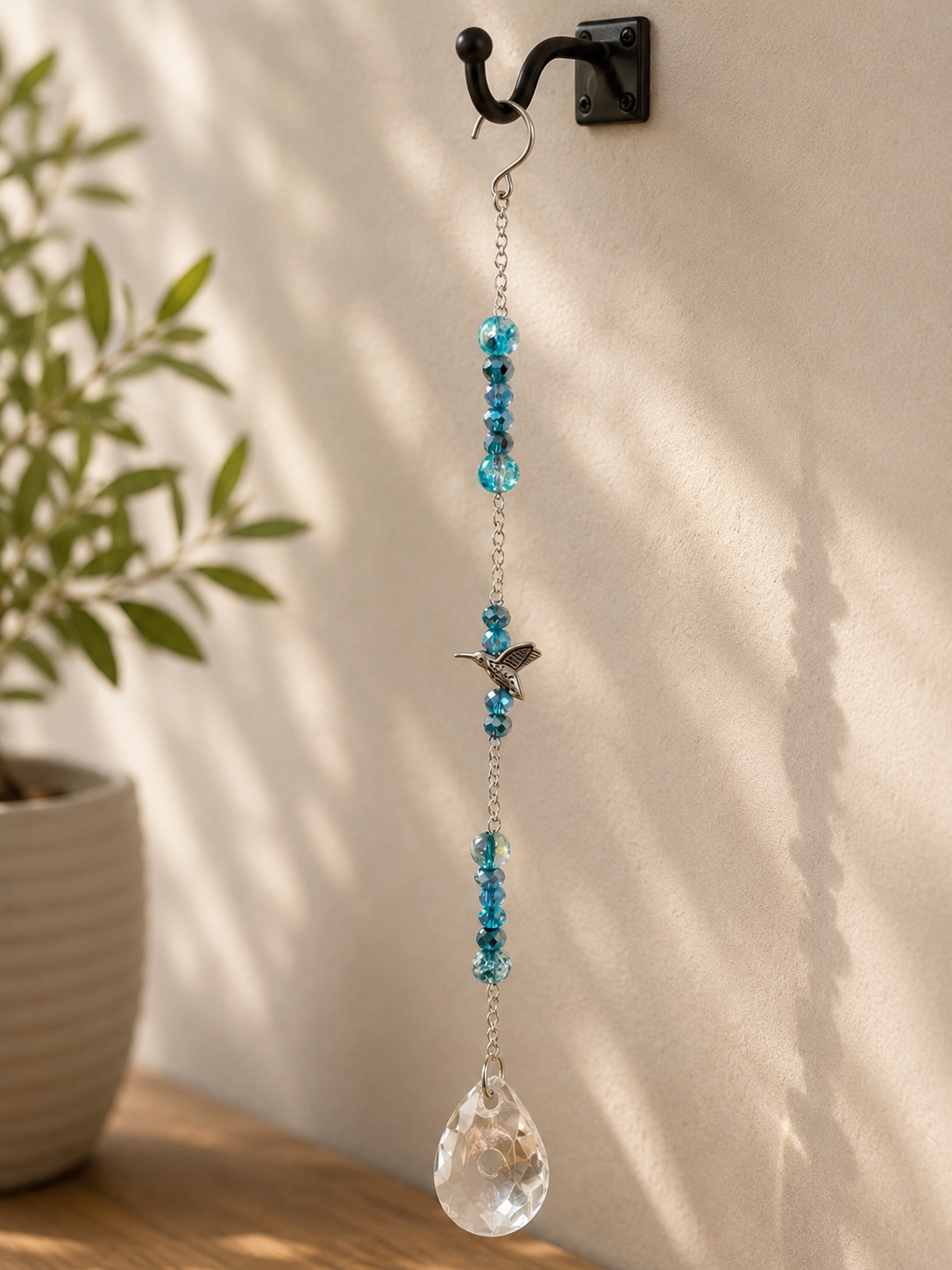 Decorative hanging crystal with blue beads on a wall