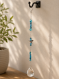 Decorative hanging crystal with blue beads on a wall